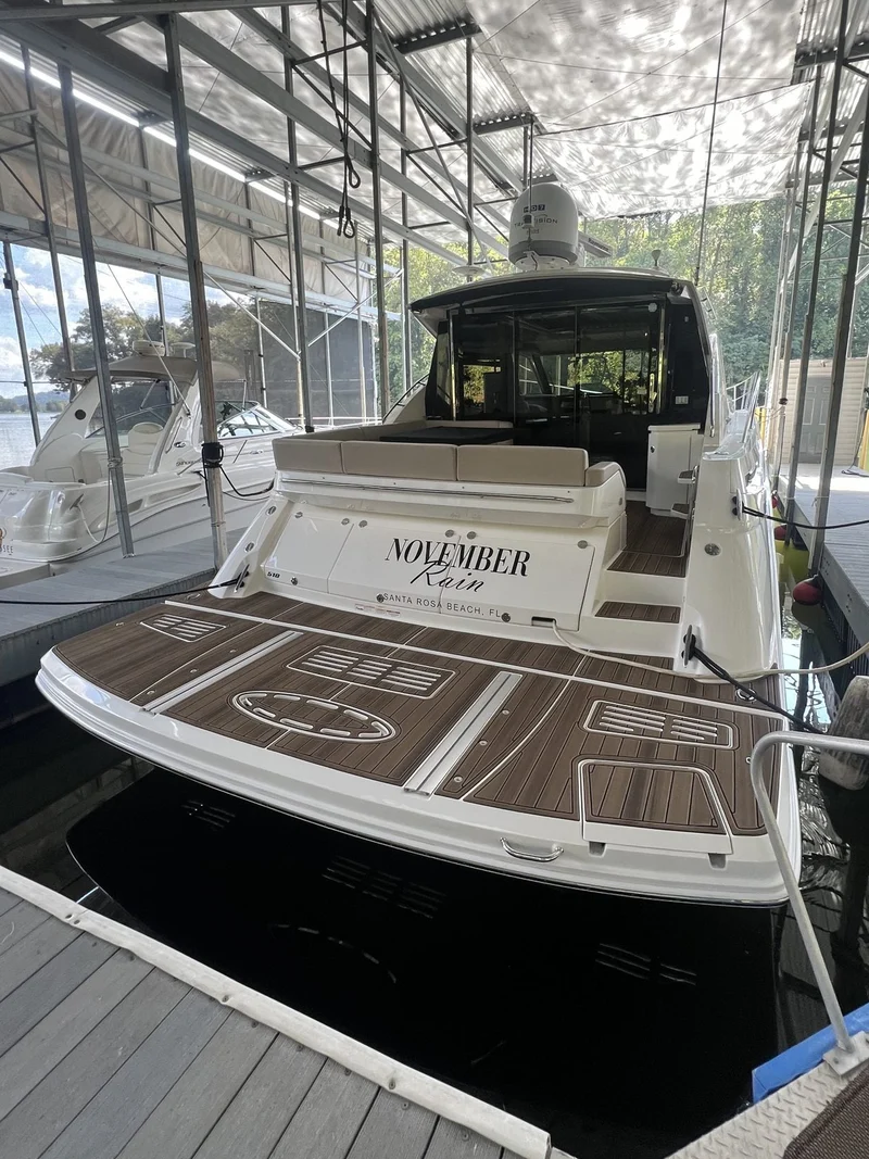 Brown teak GatorStep swim platform with custom name inlay on a cabin cruiser