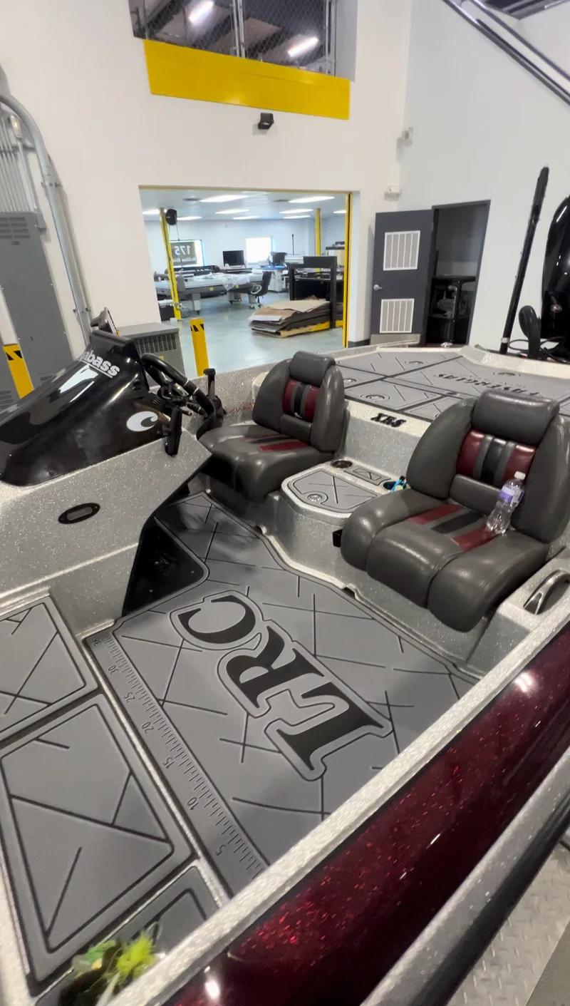 Charcoal GatorStep cockpit flooring in a bass boat with red and gray seats