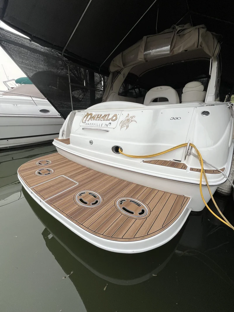 Tan teak GatorStep swim platform with Mahalo logo on a cabin cruiser