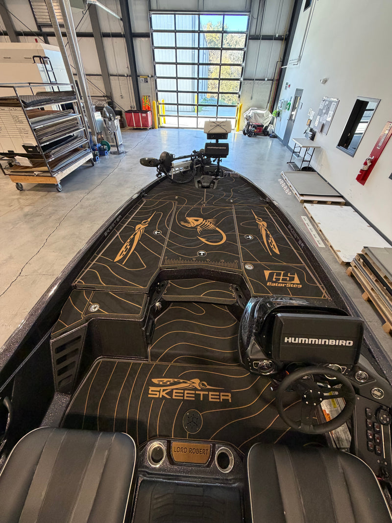 Black bass boat front deck with gold fish-skeleton GatorStep design