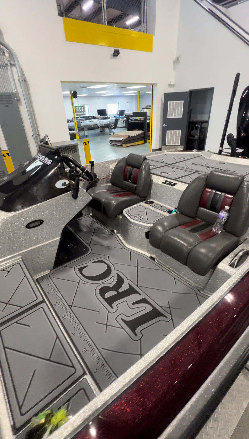 Charcoal GatorStep cockpit flooring in a bass boat with red and gray seats
