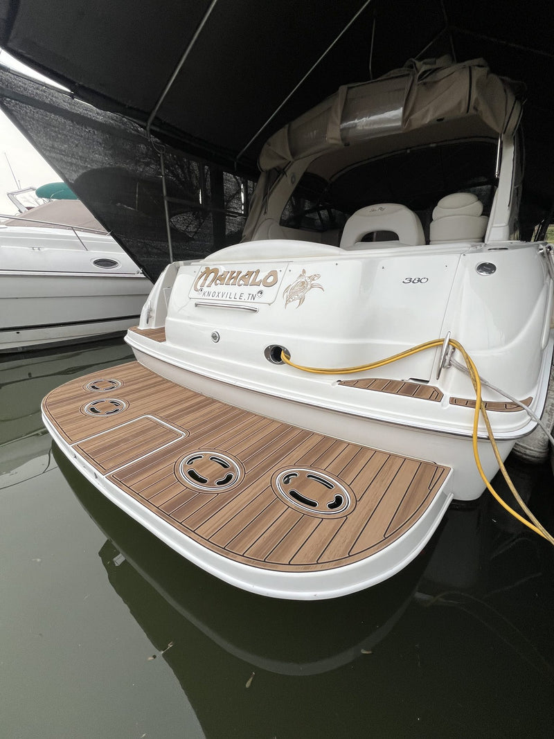 Tan teak GatorStep swim platform with Mahalo logo on a cabin cruiser